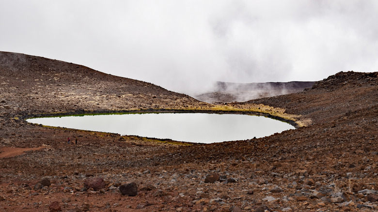 Volcanic lake reflecting cloudy sky