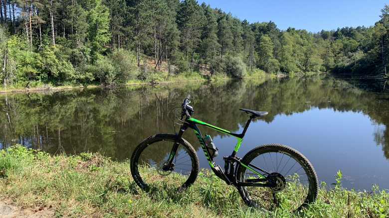 Mountain bike against lakeside and woodland in Hillman Park
