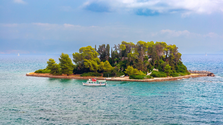 Boat in front of tree-covered Pontikionisi