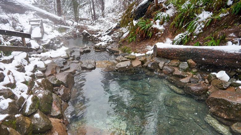 Snow covers the rocks around Terwilliger Hot Springs in Oregon.