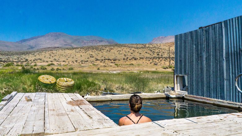 A woman soaks in a square hot spring tub in Alvord, Oregon.
