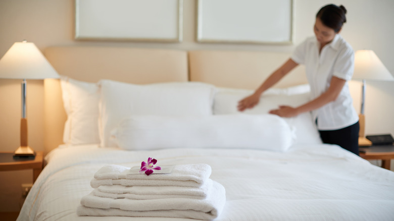 Hotel maid fluffing pillows