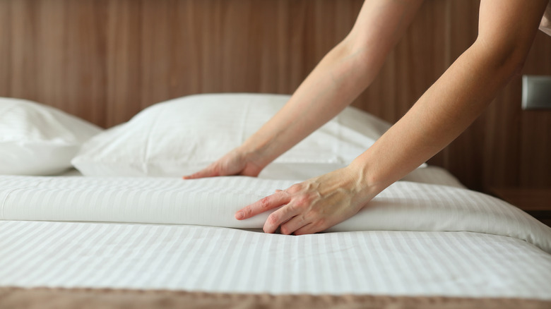 Hotel cleaning staff making a bed