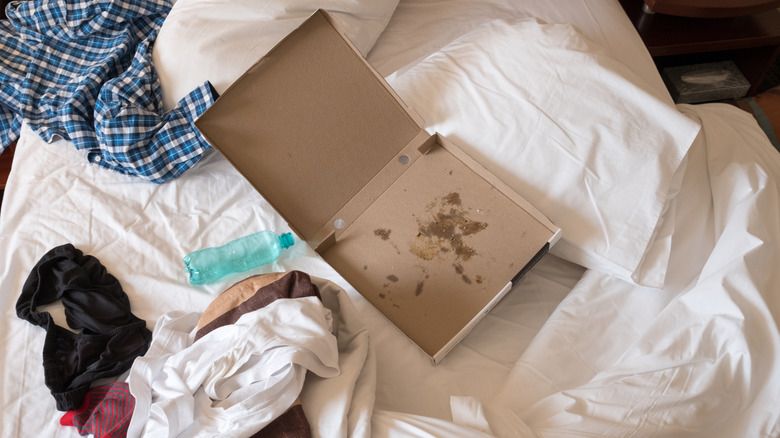 Messy hotel room with empty takeout containers.