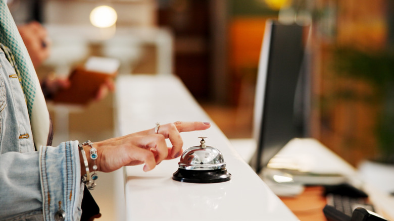 Guest ringing bell at hotel front desk