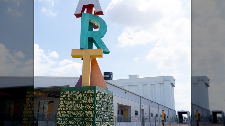 The exterior of Sawyer Yards with a large sculpture reading "ART" in the foreground along with the names of artists