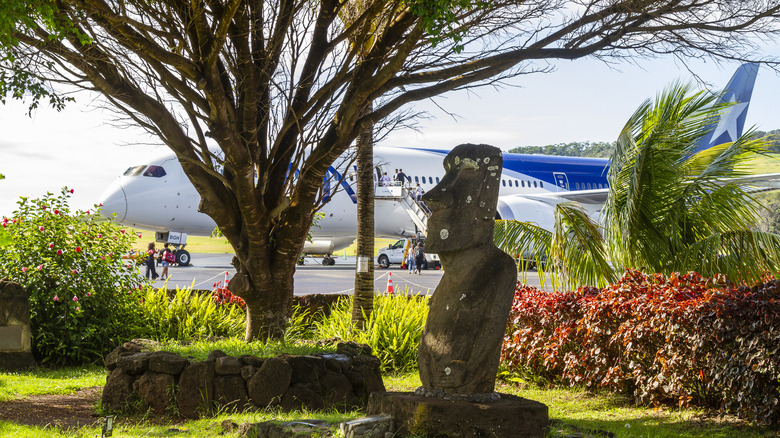Airplane at the Easter Island airport with moai sculpture