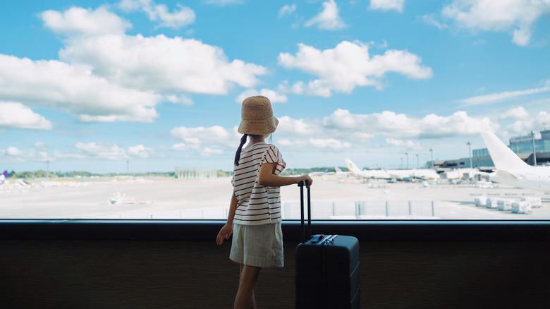 A child looks out an airport window
