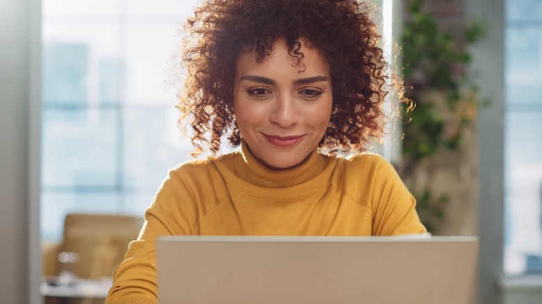 woman smiles at laptop