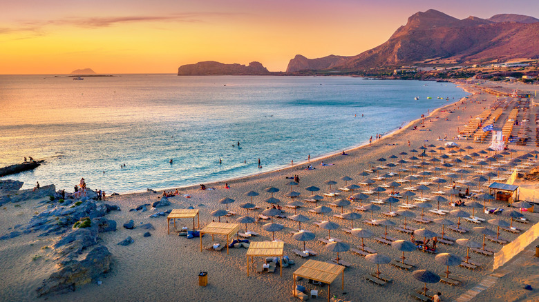 Rows upon rows of beach chaise loungers and umbrellas to rent on Falassarna Beach, Crete, Greece