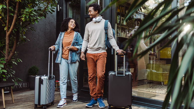 smiling couple with travel bags