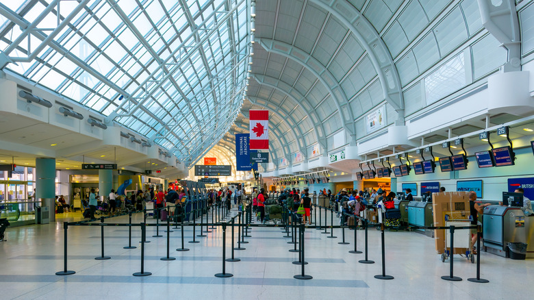 Airport check-in counters with Canadian flag hanging above