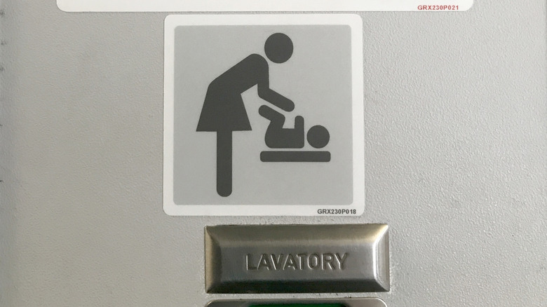 A symbol for diaper changing station on an airplane lavatory door