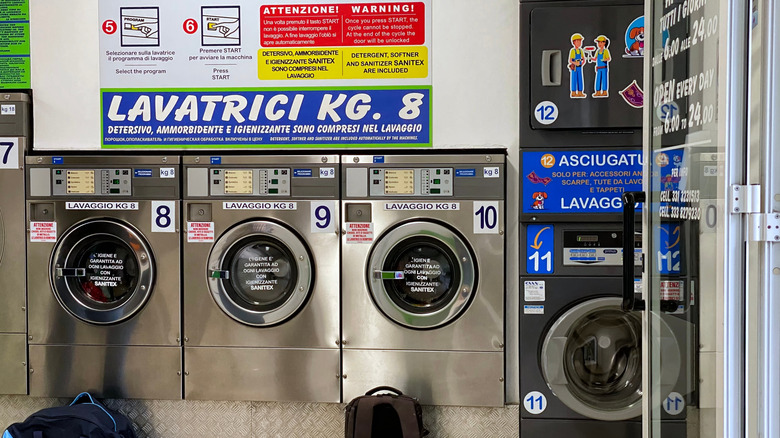 A row of machines with instructions in an Italian laundromat