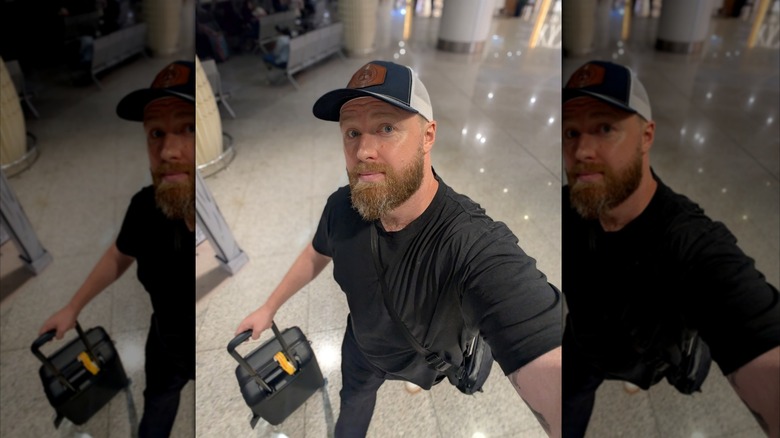 writer walking through airport with luggage