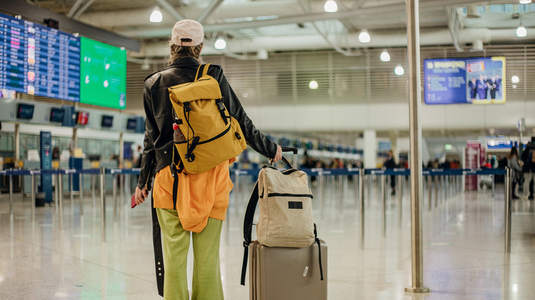 backpacker dressed for flight in airport