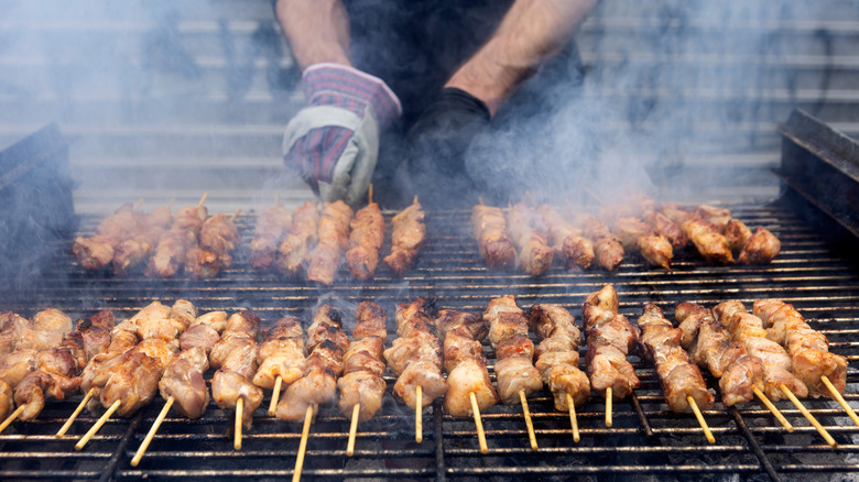 Man cooking souvlaki skewers in Greece.