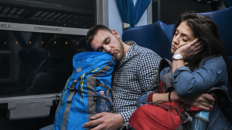 Young couple travelers sleeping in train during night