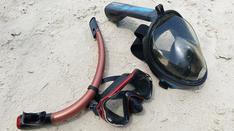 Snorkel masks on a white-sand beach.