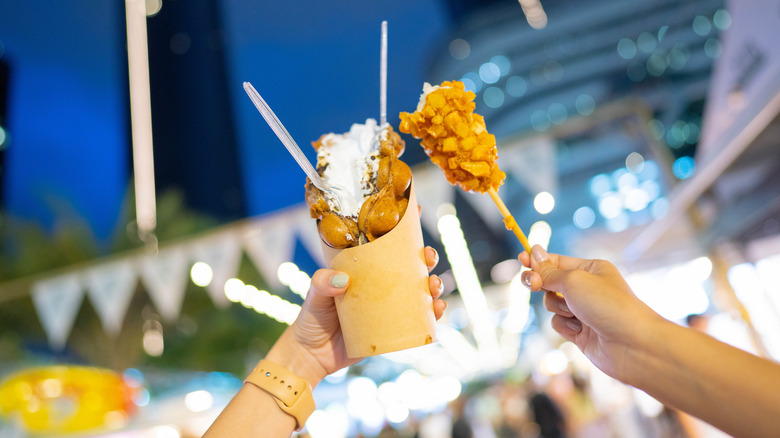 Two women enjoying food at a night market in the U.S.