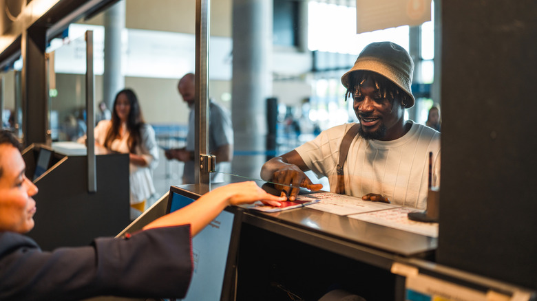A male traveler handing over his passport at the airport