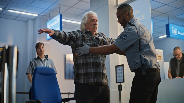 Someone getting a pat-down from a TSA agent at an airport