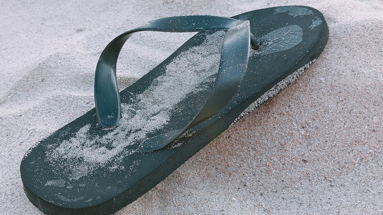A flip-flop sandal in the sand