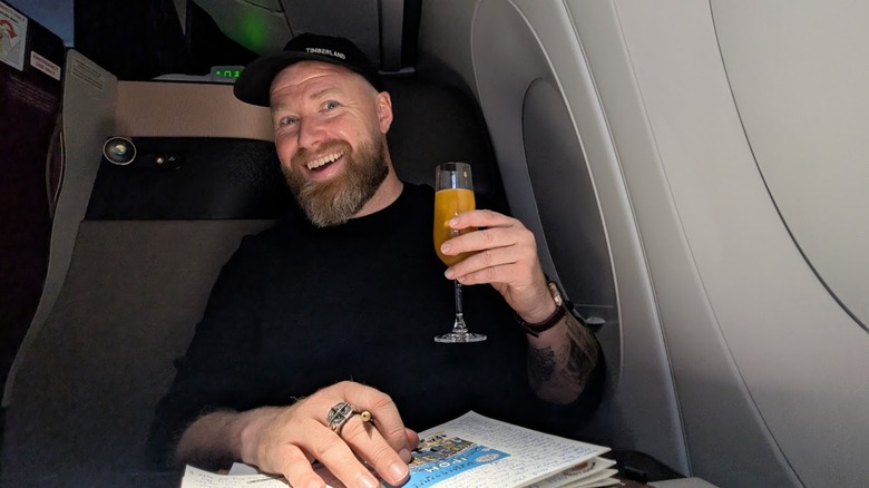 Author of article enjoying cocktail in Qatar Airways Qsuite