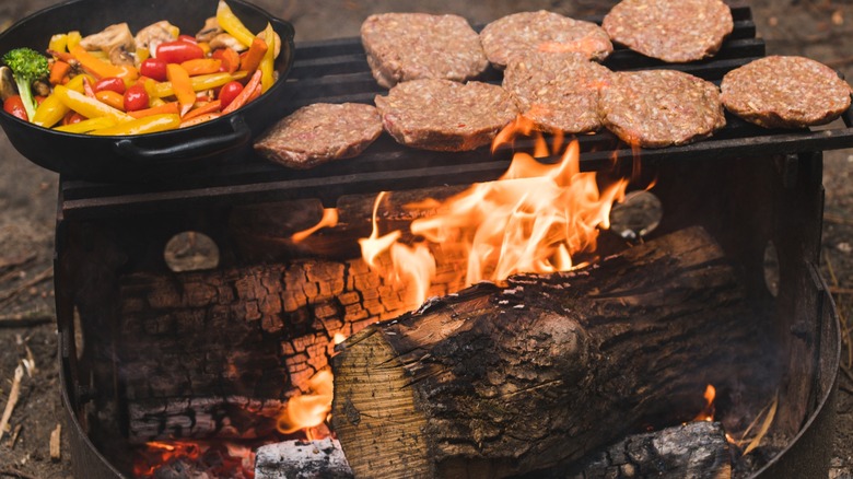 Meat and vegetables cooking over a wood burning fire