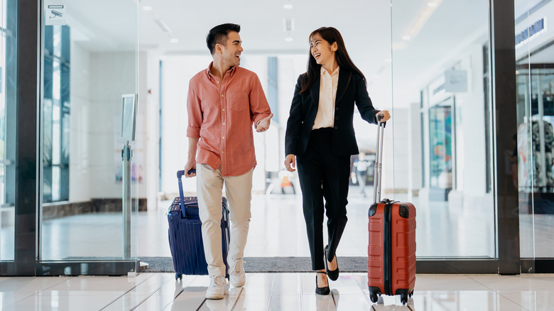Two people walking through an airport