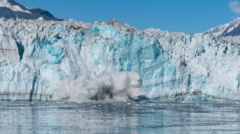 Chunk of ice breaks off glacier, falling into the ocean
