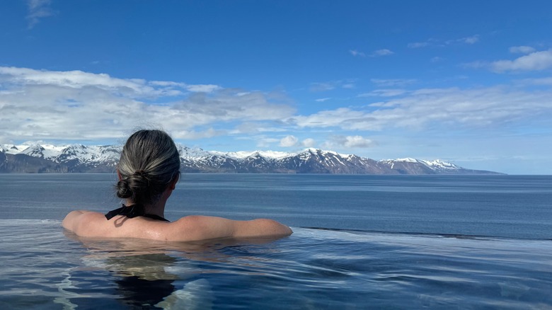 Women gazes out to sea from a hot pool in northeast Iceland
