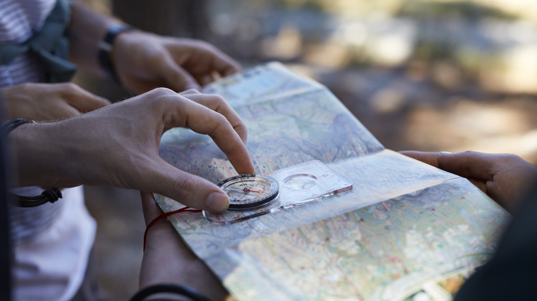 Hiking couple using a map and compass