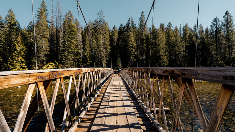 Someone walking across the footbridge over the Lochsa River to the Jerry Johnson Hot Springs