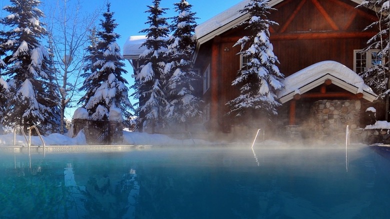 Shore Lodge's hot spring steams by snowy winter cabin