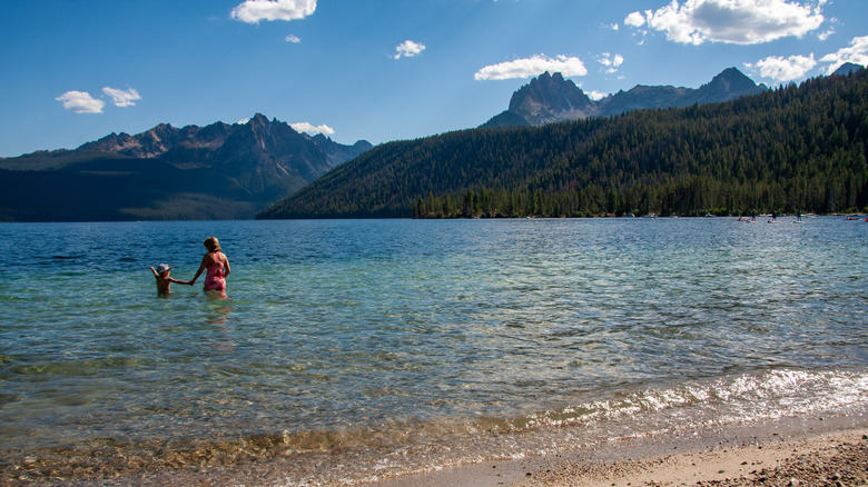 View of two people wading to the waters of Redfish Lake