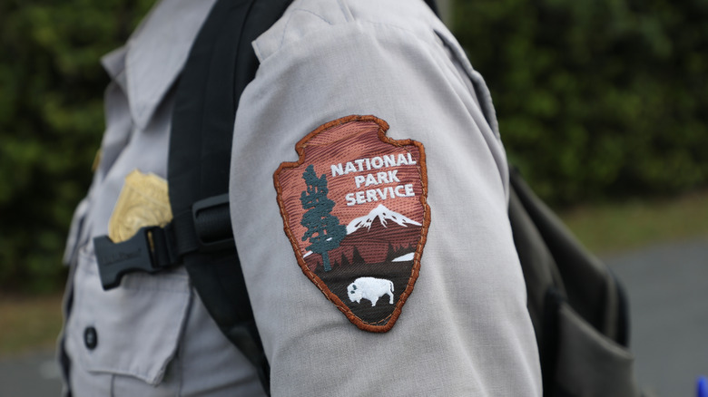 A park ranger's National Park Service badge on their uniform