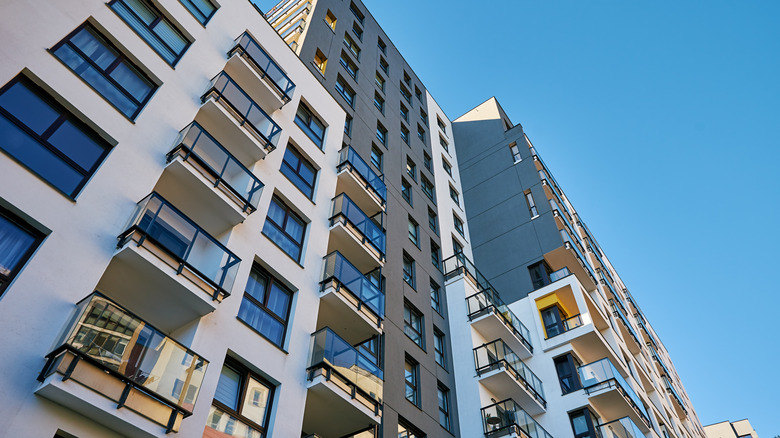A modern high-rise apartment in a city with balconies and large windows.