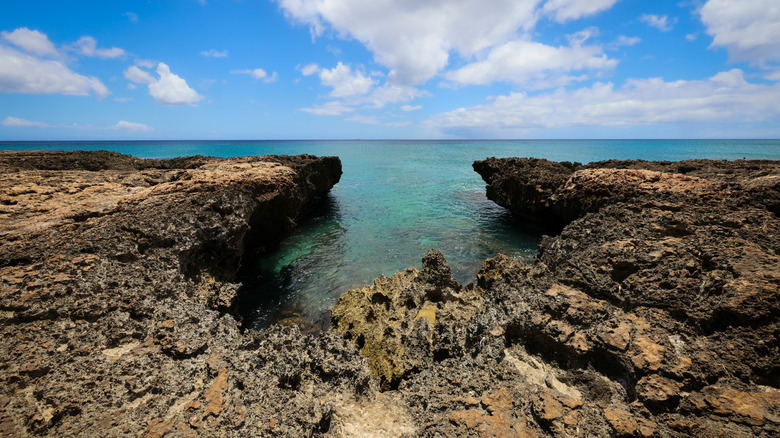Craggy rocks and turquoise sea at the Mermaid Caves in Oahu on a sunny day