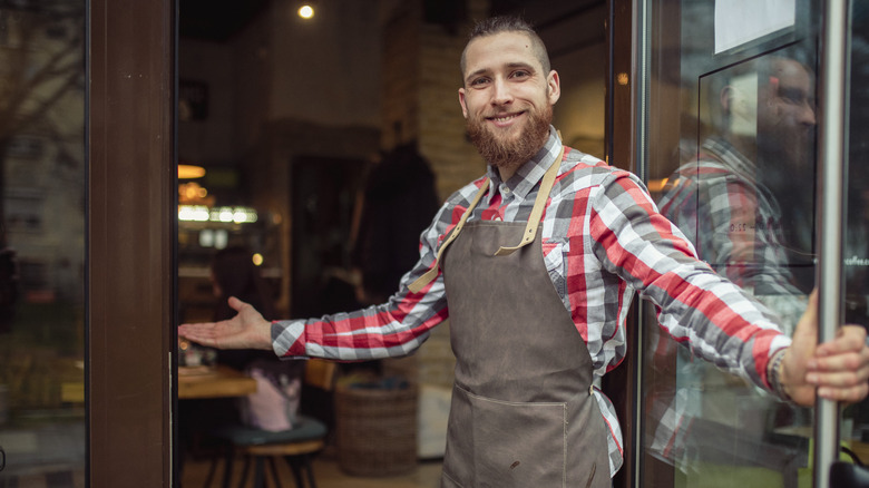 Person trying to get tourists to go inside a restaurant