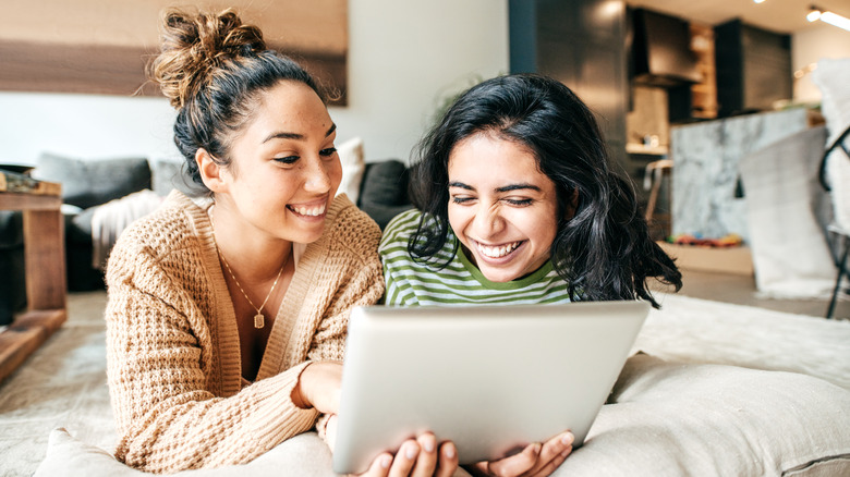 two friends look at tablet screen
