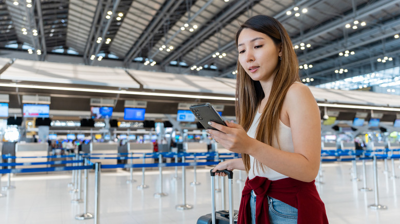A girl on her phone at the airport