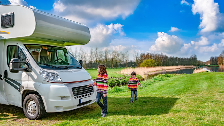 Two little girls playing near an RV.
