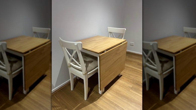 Ikea's Pinntorp Gateleg Table with two white chairs.