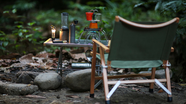 Chair and cooking gadgets on table at campsite