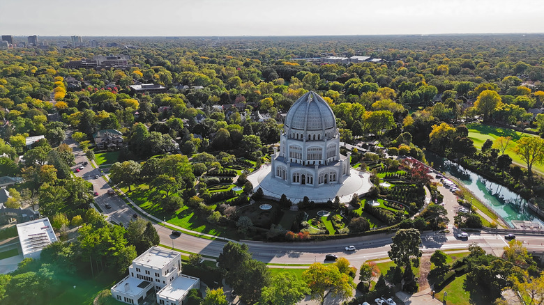 Aerial view of the ﻿﻿﻿Bahá'í House of Worship's domed temple and gardens surrounded by trees and houses in Wilmette.