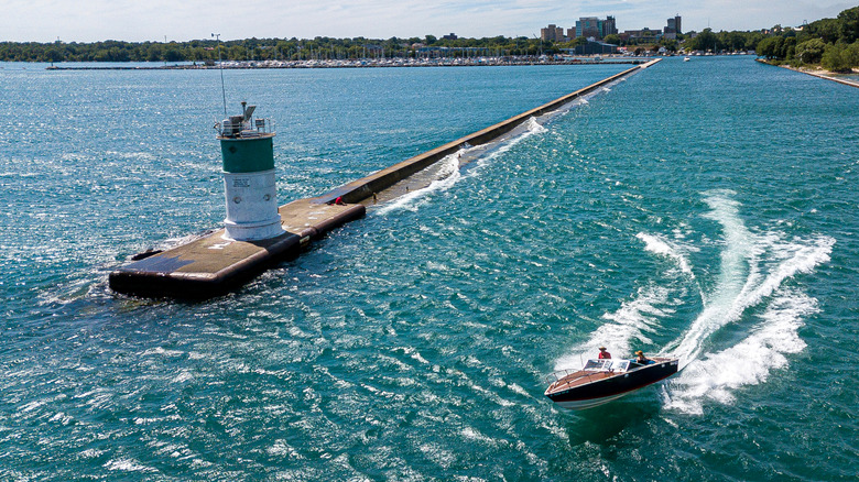 Classic boat jetting past Waukegan lighthouse.