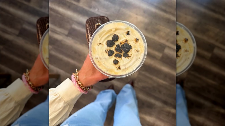 A hand holding a cup of coffee from Cafe on the Abbey in Columbia, Illinois