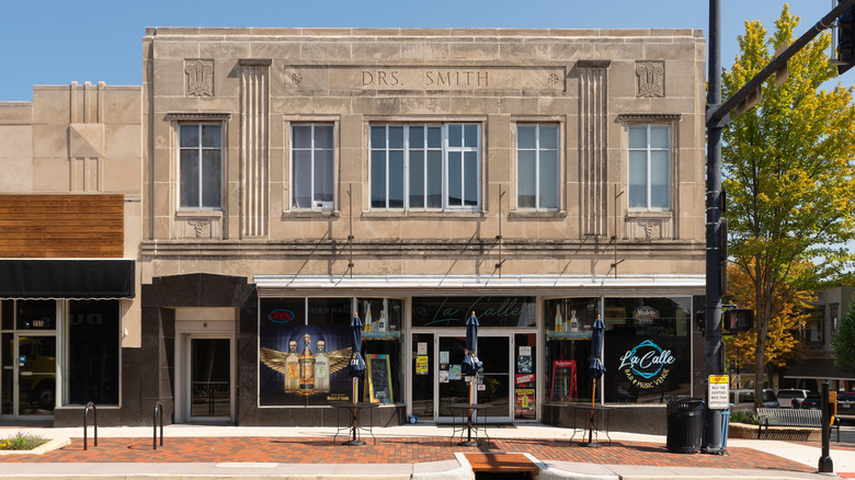 A storefront in DeKalb is a mix of a modern bar and music venue downstairs with weathered stone above.