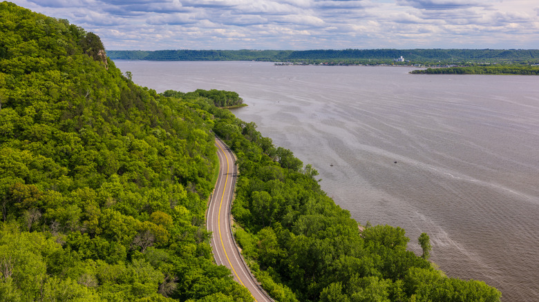 A road snakes along the Mississippi River in summertime